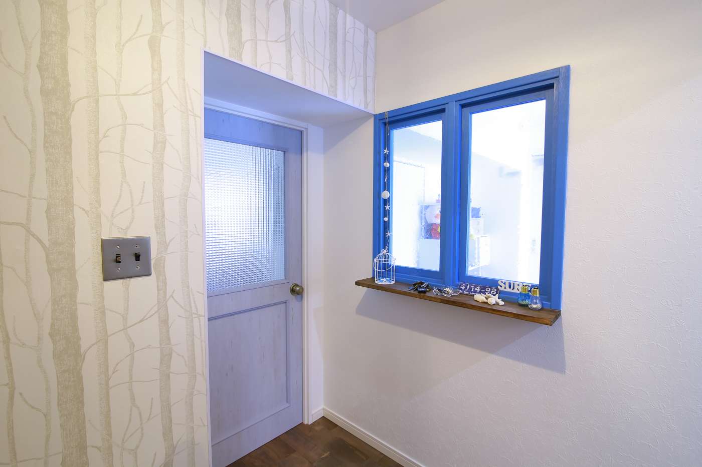 ウッド調のドアと青い小窓で西海岸の雰囲気をアップ