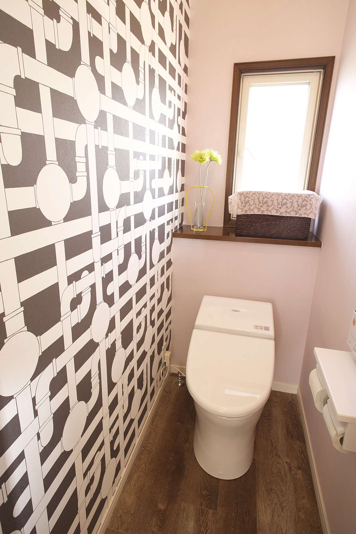 配管がデザインされた壁紙が特徴的なトイレ